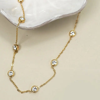 Close-up of rhinestone charms with gold edge detailing on 18K stainless steel station necklace