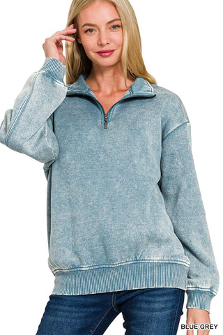 Woman modeling a blue grey acid wash quarter zip sweatshirt with soft fleece lining.
