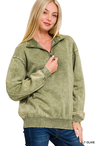 Woman wearing a light olive acid wash fleece quarter zip sweatshirt with soft fleece lining.