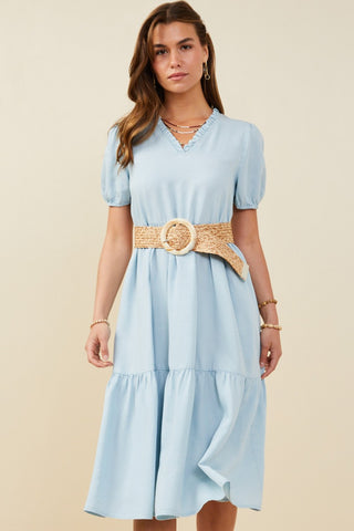 Model wearing a light blue chambray midi dress with puff sleeves and a tiered skirt, styled with a woven belt (not included) for a flattering, summery look.