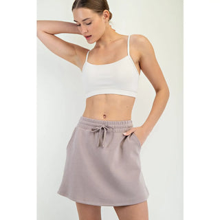 Model wearing a light mocha modal scuba skort with an elastic drawstring waistband and relaxed A-line silhouette — effortlessly chic and comfy for everyday wear.