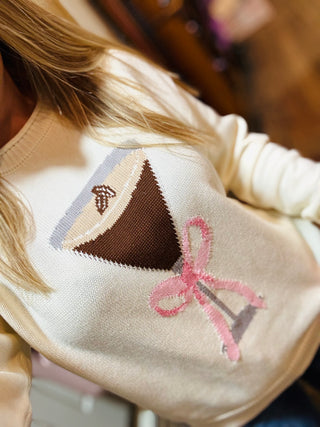 Close-up of espresso martini graphic on cream knit sweater showing chocolate and pink details.