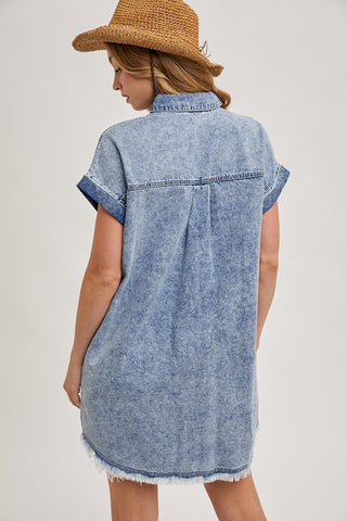 Back view of a relaxed fit denim shirt dress featuring a frayed hem and cuffed short sleeves — ideal for layering or wearing solo in warm weather.