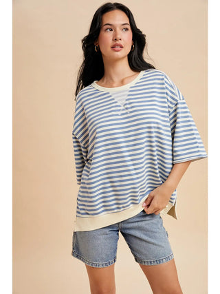 Model wearing blue and cream striped French Terry short sleeve top with relaxed oversized fit styled with denim shorts.