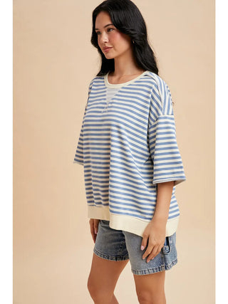 Side view of blue and cream striped french terry short sleeve top featuring dropped shoulders and relaxed silhouette.