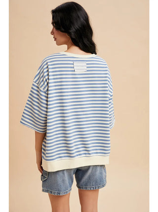 Back view of blue striped French Terry short sleeve sweatshirt-style top with cream banded hem.