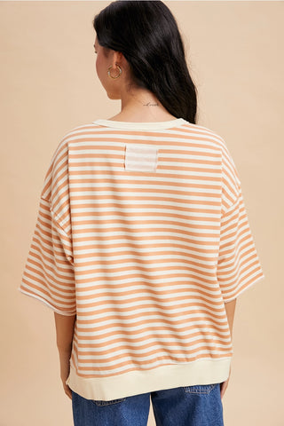 Back view of apricot and cream French terry short sleeve top with cream banded hem and relaxed silhouette.