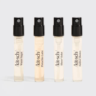 Four Kitsch sample hair perfume vials labeled Warm Sugar, Pistachio Latte, Sheer Violet, and Amber Shores displayed standing in a row.