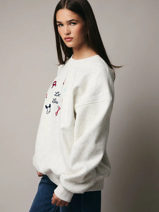 Side view of model wearing the light grey Let It Snow Sweatshirt with relaxed fit and ribbed trim.