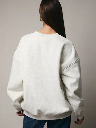 Back view of the cozy fleece Let It Snow Sweatshirt showing solid light grey fabric.