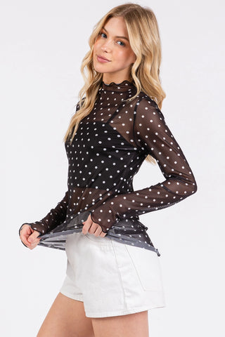 Side view of sheer black polka dot blouse showing ruffle neckline and sheer sleeve