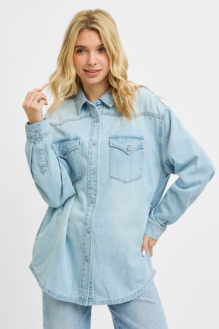 Model wearing a buttoned-up light wash denim shirt with western yoke and front flap pockets — timeless and versatile for any wardrobe.