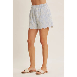Side view of stripe embroidered scallop shorts showing side pockets and relaxed fit