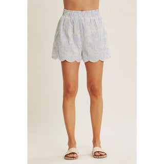 Close-up of textured stripe fabric and delicate embroidery detail on scallop hem shorts
