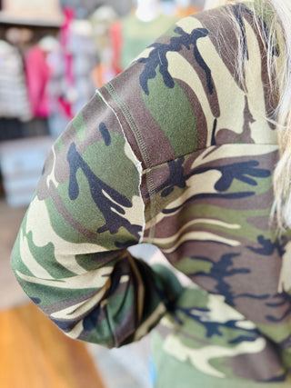 Close-up of camo sweatshirt sleeve seam showing fabric texture and stitching detail