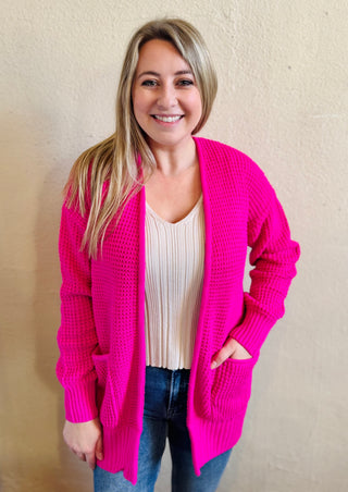 Model wearing the hot pink waffle knit open front cardigan with pockets styled casually with denim