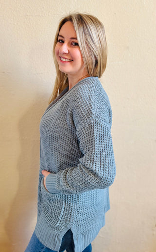 Side view of blue grey waffle knit cardigan showing relaxed fit and texture throughout