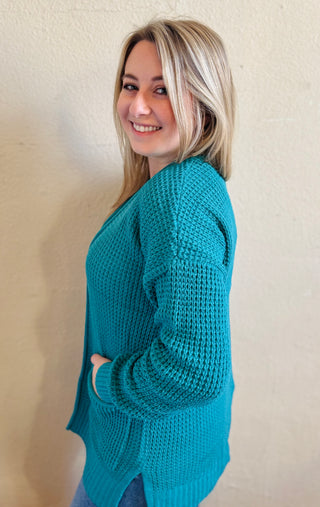Side view of the light teal waffle knit cardigan showing relaxed fit and texture throughout