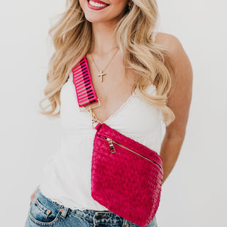 Model styling the hot pink Westlyn woven bum bag with matching pink striped strap and gold zipper detail.