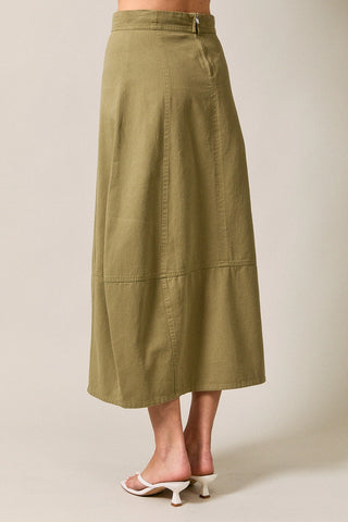 Back view of the barrel, olive green skirt worn by a woman on a beige background. Shows the midi , mid calf length and zipper closure on the back top of the skirt.