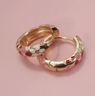 Close-up of gold plated enamel flower huggie hoops showing hinge back closure detail