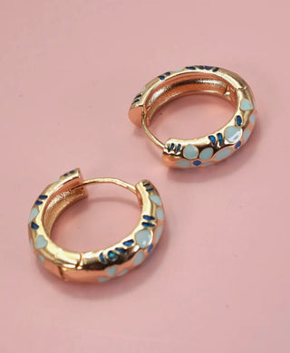 Close-up of gold plated enamel flower huggie hoops showing hinge back closure detail