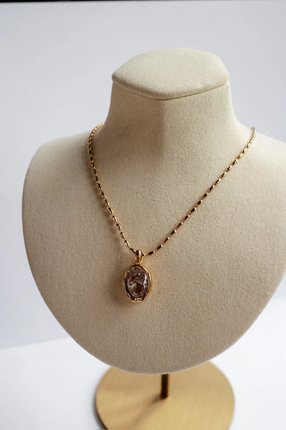 Eva Waterproof Gold Pendant Necklace displayed on a jewelry bust — gold oval crystal pendant on a delicate gold chain, tarnish resistant stainless steel