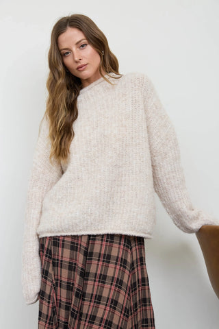 Front view of women's cream fuzzy knit pullover sweater with raw edge mock neckline and drop shoulder silhouette