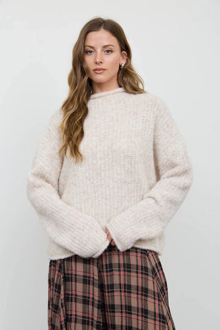 Women's cream fuzzy knit mock neck pullover sweater with long sleeves and drop shoulder, styled with plaid midi skirt