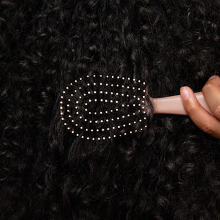 Terracotta mini detangling brush showing bendable bristle design for gentle hair detangling
