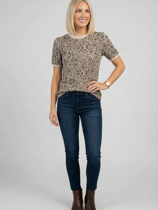 ront view of women's leopard print short sleeve knit top with relaxed fit and contrast trim neckline, styled with dark denim