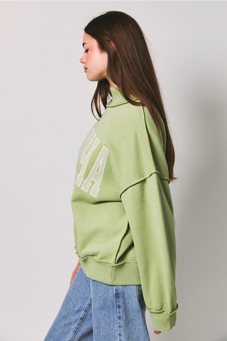 Matcha Embroidered Mock Neck Sweatshirt – side view showing raw edge seam detail and oversized relaxed fit in light green