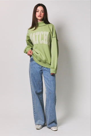 Matcha Embroidered Mock Neck Sweatshirt styled with wide-leg jeans – full length front view of oversized green fleece pullover