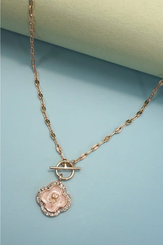Gold plated rhinestone rose pearl charm toggle necklace with T-clasp and link chain on blue background