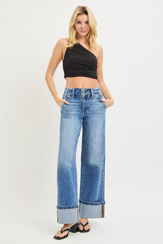 Model wearing Risen high rise cuffed wide leg jeans with black one-shoulder crop top – full length front view showing slanted front pockets and wide cuffed hem