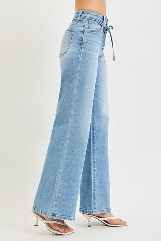 Side view of Risen high rise wide leg jeans with tie waist detail – light wash denim showing high rise waistband and wide leg silhouette