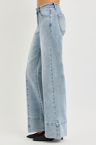 Side view of Risen tummy control mid rise wide flare jeans in light wash – showing center pintuck seam, mid rise waistband, and ankle flare silhouette