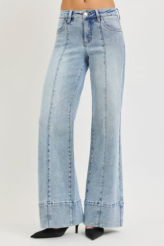 Risen tummy control mid rise ankle wide flare jeans in light wash – 3/4 front view showing center seam pintuck detail and wide flare ankle hem