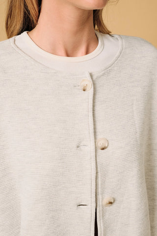 Closeup of Round Neck Barrel Hem Knit Jacket — textured ash grey knit fabric with round neckline and 5-button front closure detail