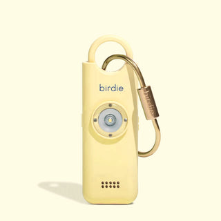 She's Birdie 3.0 personal safety alarm in Butter Yellow with brass keychain and front-facing light.