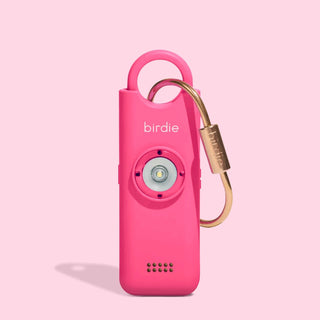 She's Birdie 3.0 personal safety alarm in Hot Pink with brass keychain and front-facing light.