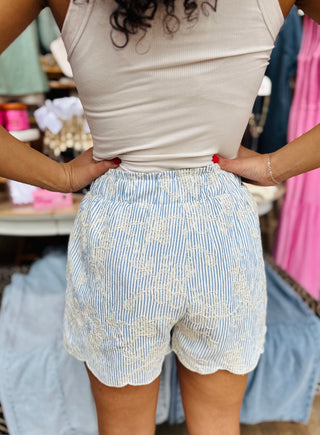 Back view of white embroidered scallop shorts with elastic waistband and scalloped hem