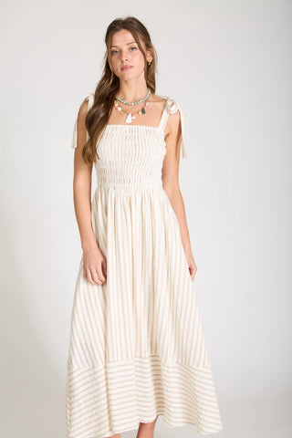 Woman wearing a striped, midi dress with basque style waistline in light ivory and taupe color combo.