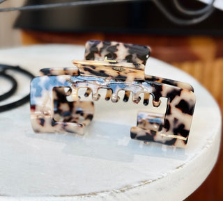 Large blonde tortoiseshell colored hair claw clip featuring a unique design with missing space to wear your hair up with a trucker or baseball hat.