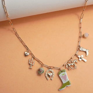 Close-up of vibrant colored boot charms with horse and cross on Western cowgirl necklace showing detail